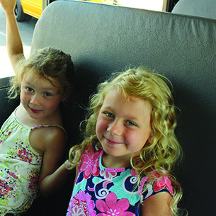  two girls smiling on a bus